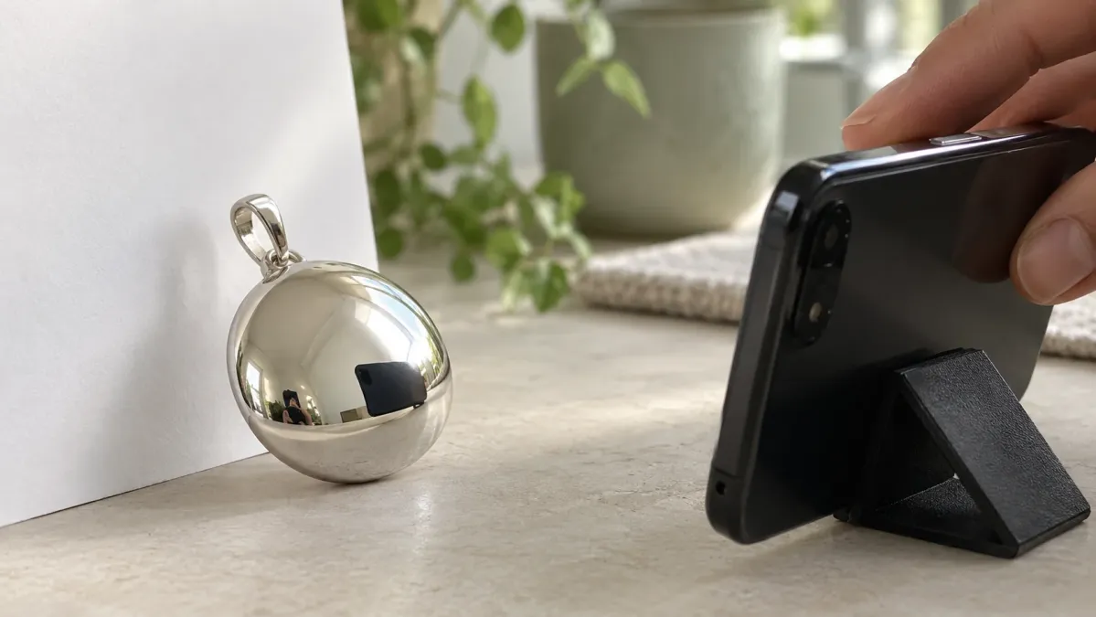 Parlak kolye yüzeyindeki koyu telefon yansımasına bakılarak çekim açısı ayarlanıyor.